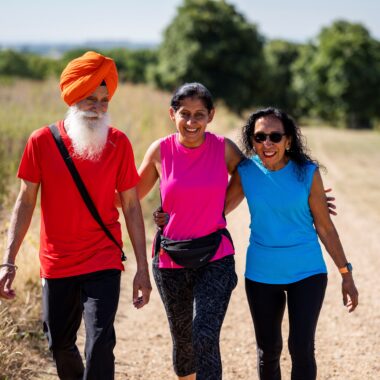 three people walking through a field