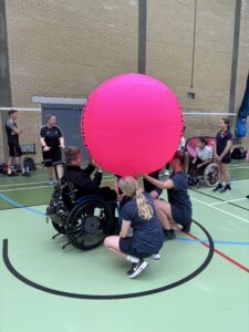 group of young people holding up a kin-ball