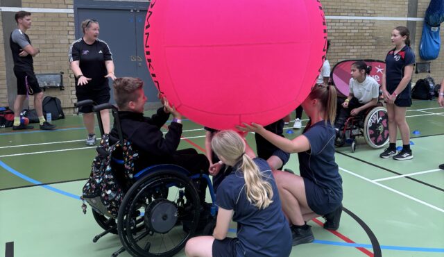 group of young people holding up a kin-ball